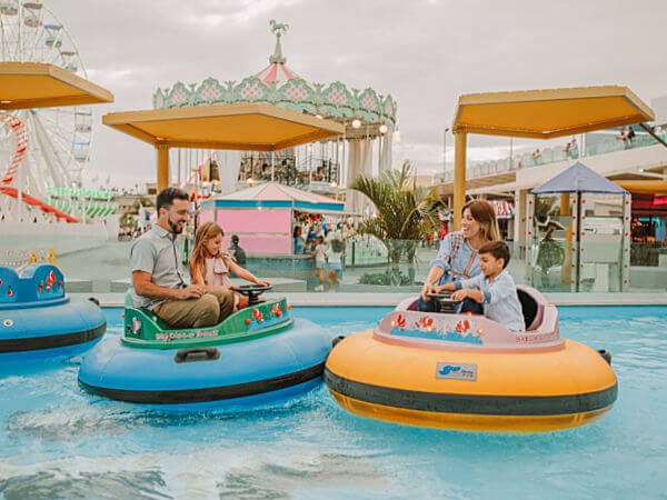 family playing bumper cars in water