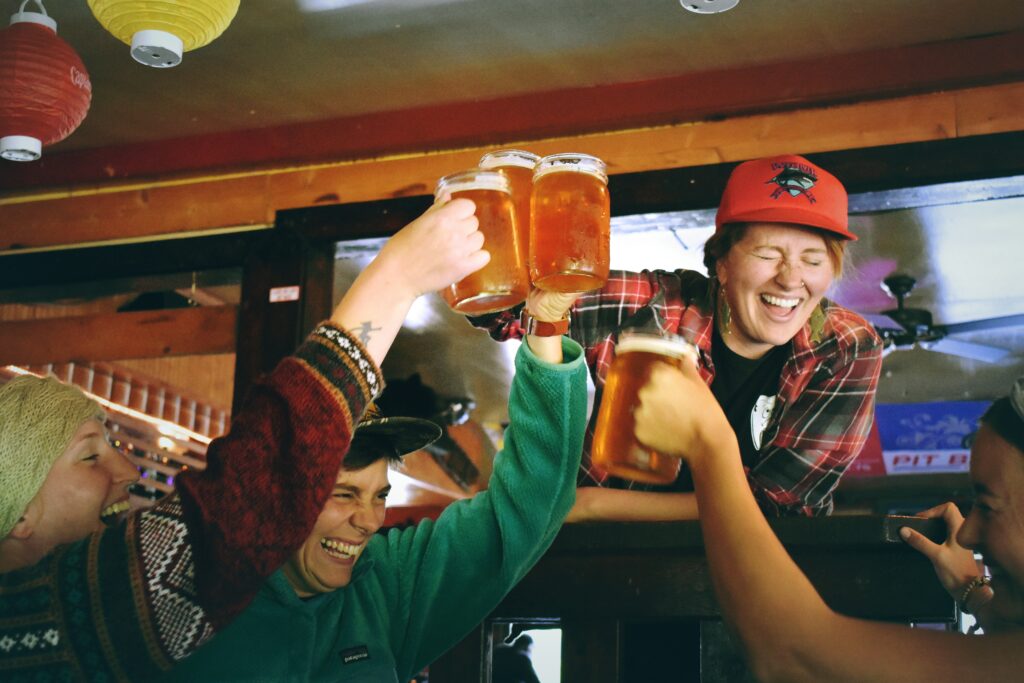 friends having a laugh at a bar while drinking beer