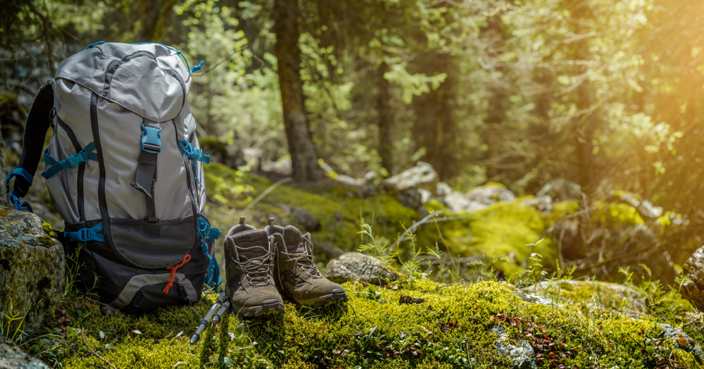 backpack and hiking boots in the forest